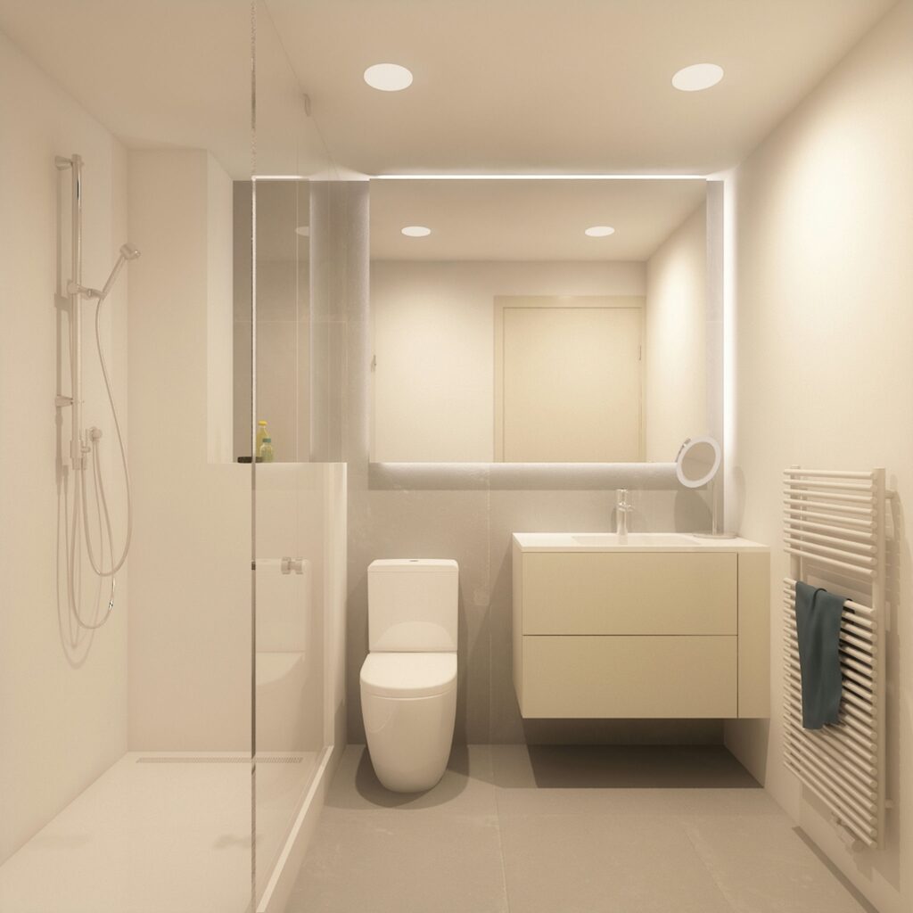 Diseño de baño moderno con estética minimalista en Barcelona Baño contemporáneo en Barcelona con ducha de cristal sin marco, inodoro blanco y tocador montado en la pared, iluminado por un gran espejo.