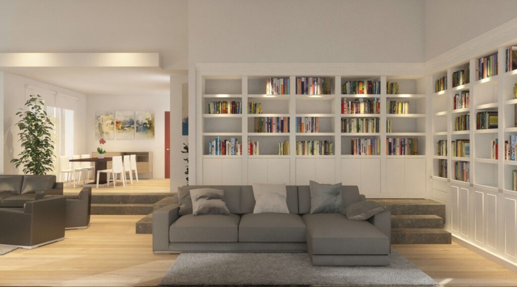 Salón-comedor en Sant Cugat del Vallès: Amplio salón moderno en Barcelona con sofá gris, sillón negro, y estantería integrada, iluminado por luz natural.