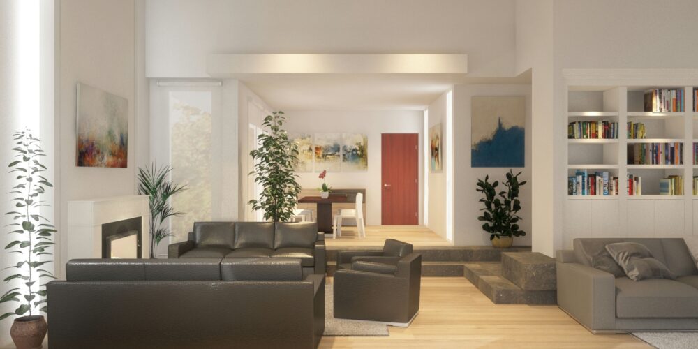 Interior luminoso y espacioso de un salón moderno en Barcelona con sofás de cuero oscuro y una silla clara, iluminado por luz natural y decorado con plantas verdes y arte abstracto.