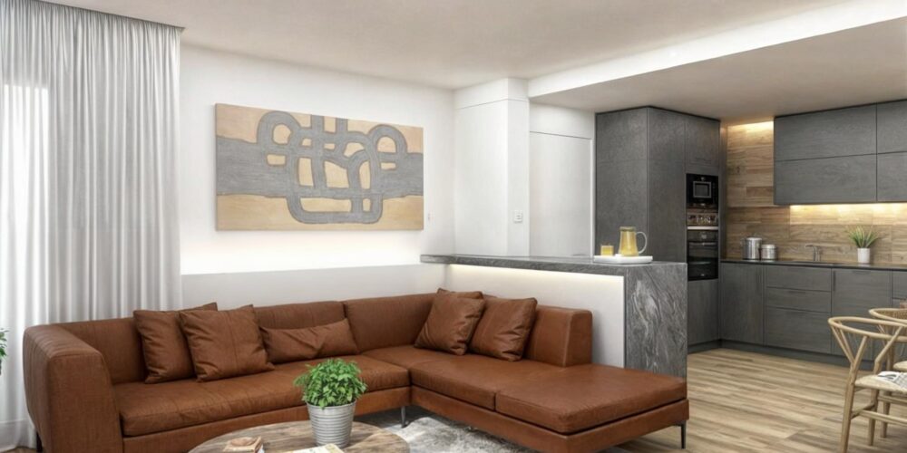 Moderno salón de diseño de interiores en Barcelona con sofá de esquina marrón, mesa de café circular de madera y elegante cuadro en la pared. Cocina visible al fondo con armarios grises y iluminación cálida, destacando materiales de alta calidad como madera y mármol.