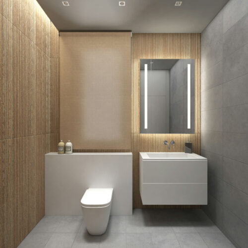 Interior de baño moderno en Barcelona, diseñado con elementos de alta calidad, incluyendo un inodoro blanco y un lavabo contemporáneo con un mueble minimalista. Las paredes presentan paneles de madera cálida y azulejos grises, resaltando funcionalidad y estética, con iluminación LED integrada y un espejo retroiluminado que mejora el ambiente.