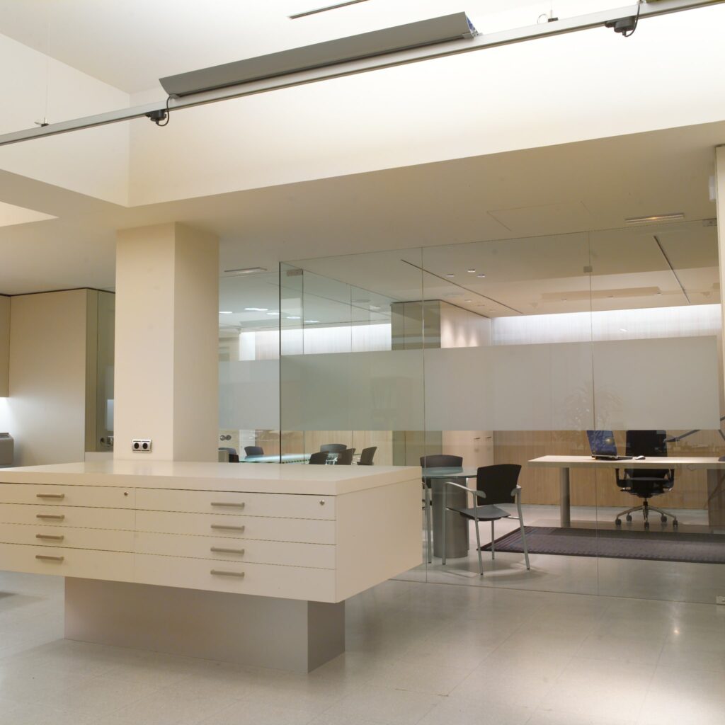 Área de Recepción de Oficina Minimalista y Elegante con Partición de Vidrio Área de recepción de oficina moderna con un escritorio blanco, partición de vidrio, mesa de conferencias y sillas ergonómicas en un espacio bien iluminado con colores neutros.