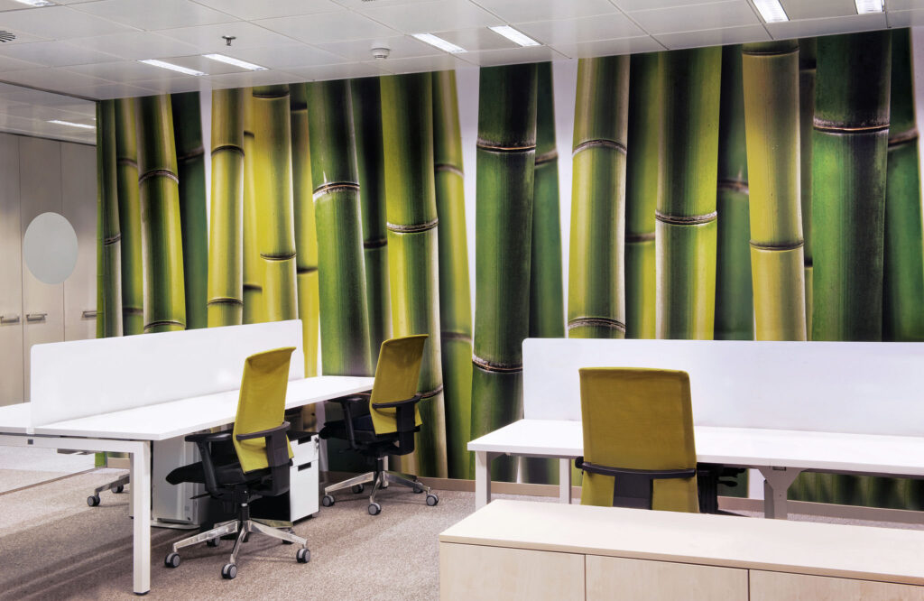 Espacio de Oficina Moderno con Murales de Bambú y Escritorios Elegantes Un interior de oficina contemporáneo con un vibrante mural de bambú en tonos verdes, dos escritorios blancos y sillas ergonómicas en negro y verde lima.
