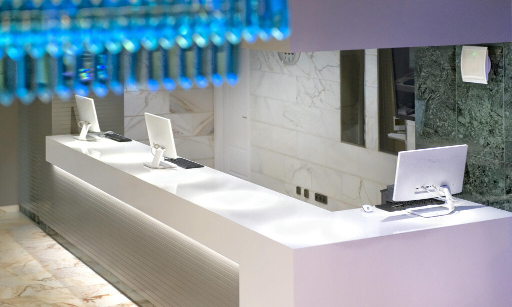 Recepción moderna y minimalista Recepción con mostrador blanco y detalles elegantes en un espacio luminoso