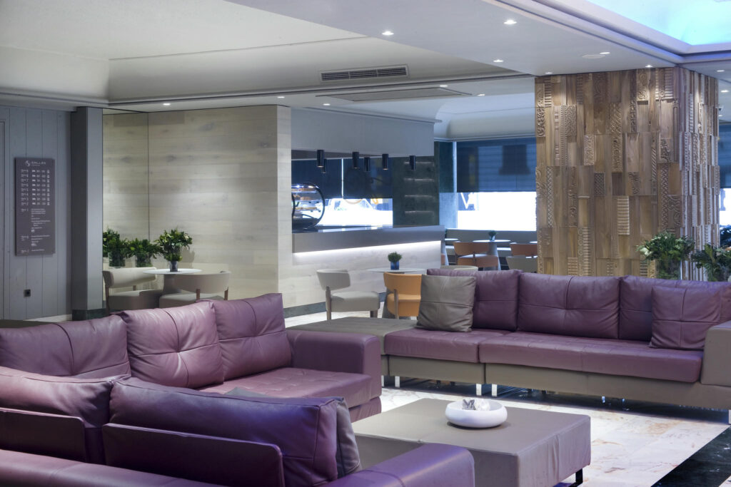 Salón moderno y acogedor Salón contemporáneo con sofás morados y pared de madera decorativa.