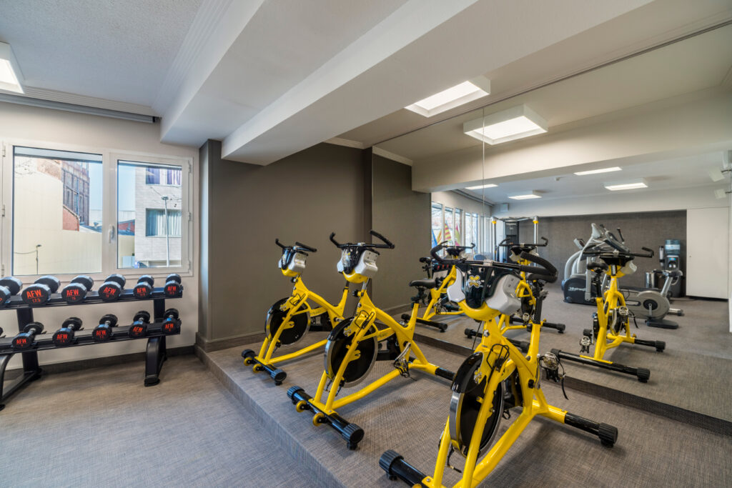 gimnasio moderno y funcional gimnasio iluminado con bicicletas amarillas y pesas de acero