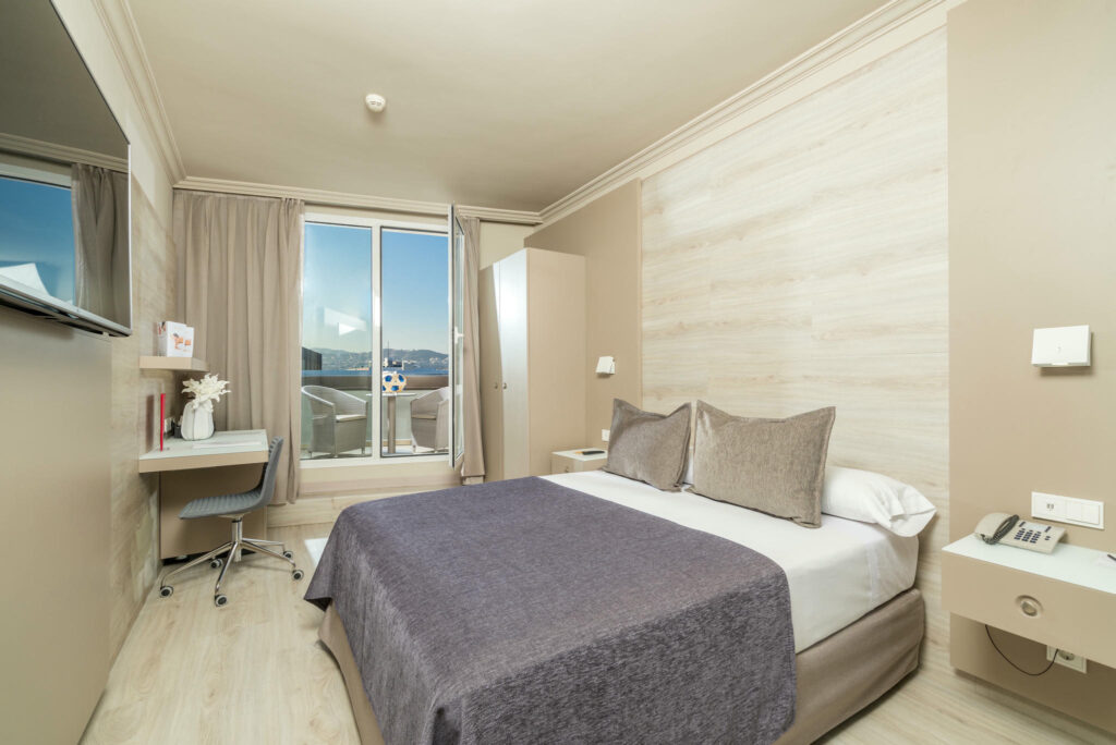 Dormitorio moderno minimalista Habitación minimalista con cama, escritorio y muebles en madera clara.