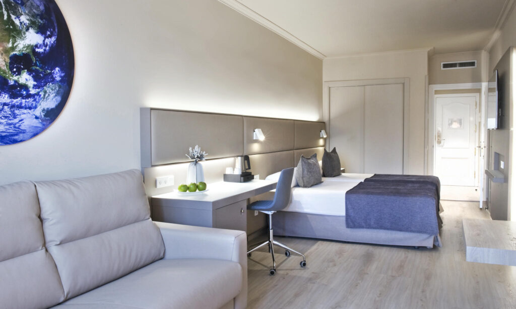 Habitación moderna y elegante Habitación contemporánea con cama y sofá luminoso.