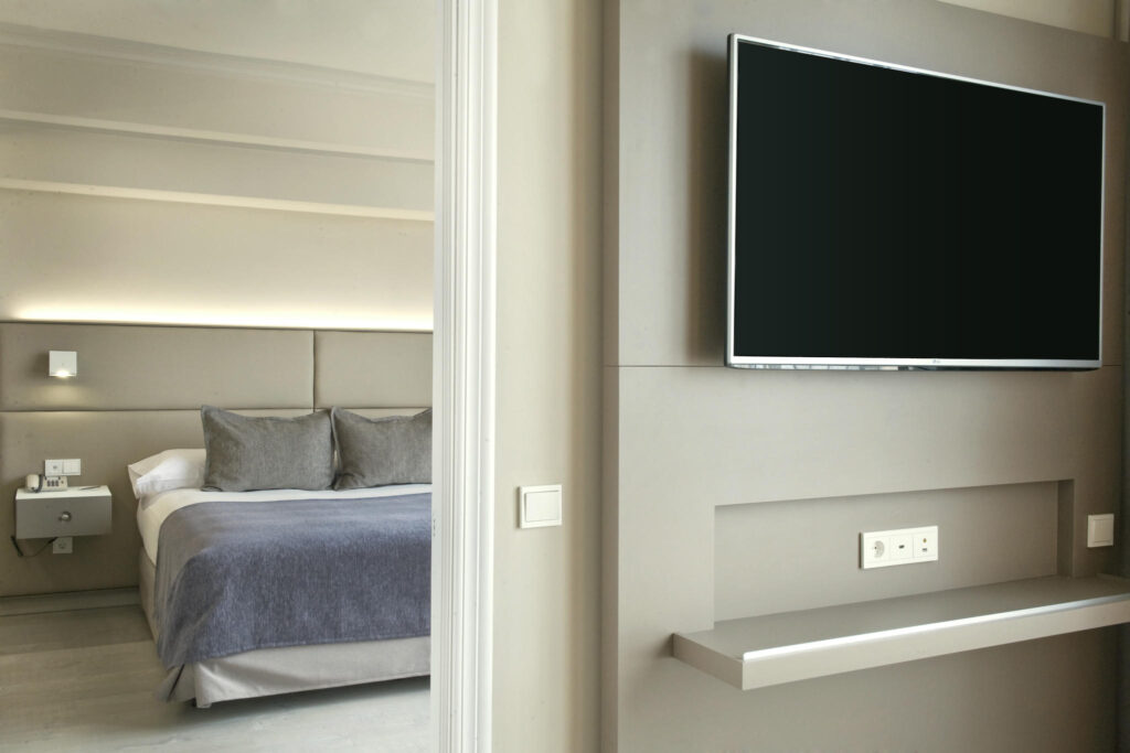 Dormitorio moderno y acogedor Dormitorio elegante con cama, televisor y detalles minimalistas