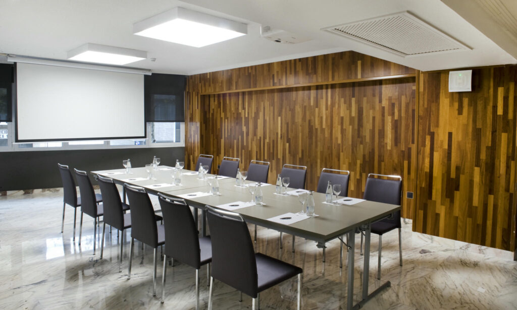 Reunión Moderna en Espacio Elegante Sala de reuniones contemporánea con mesa larga y sillas modernas, con paredes de madera que resaltan la luminosidad natural.