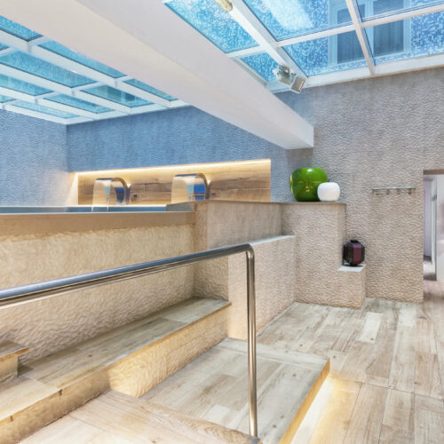 Diseño de spa con escaleras de madera y detalles naturales.
