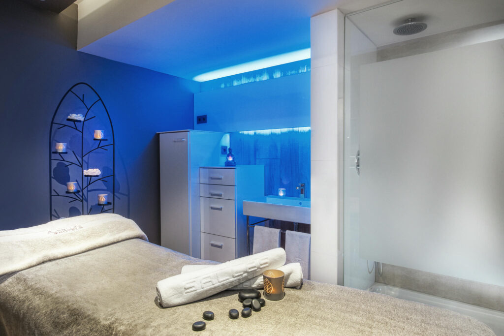 Spa moderno con iluminación azul Spa interior moderno con luz azul y elementos de piedra.