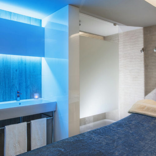 Baño moderno con iluminación suave y acabados de cerámica.