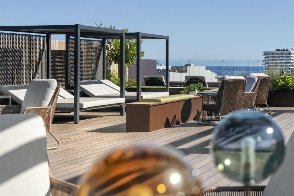 Terraza moderna y acogedora Terraza elegante con muebles de ratán y vistas al mar.