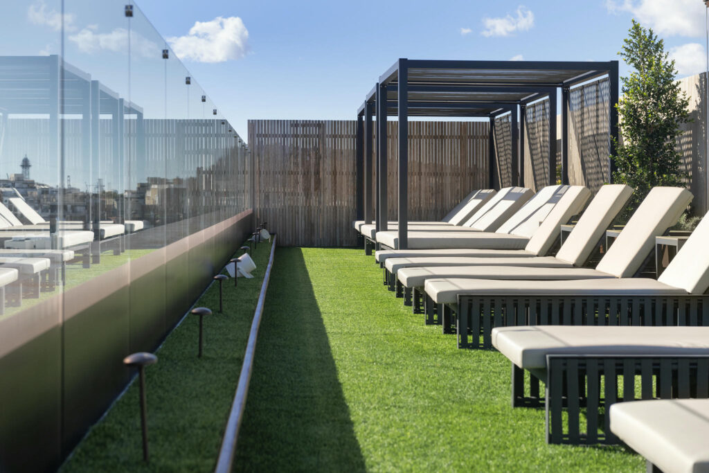Terraza moderna y elegante Terraza con tumbonas de madera y césped verde