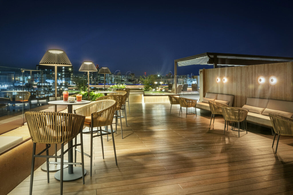 Terraza contemporánea elegante Terraza iluminada con sillas de mimbre y mesas elegantes
