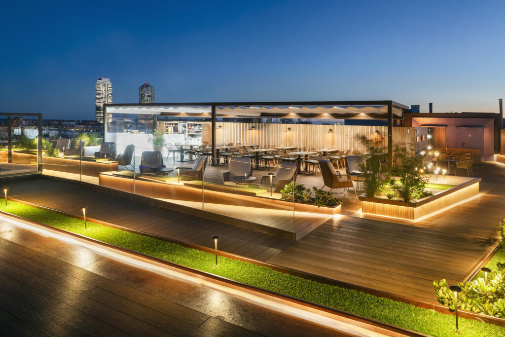 Terraza Moderna y Acogedora Terraza iluminada con muebles de madera y plantas, perfecta para cenas al aire libre.