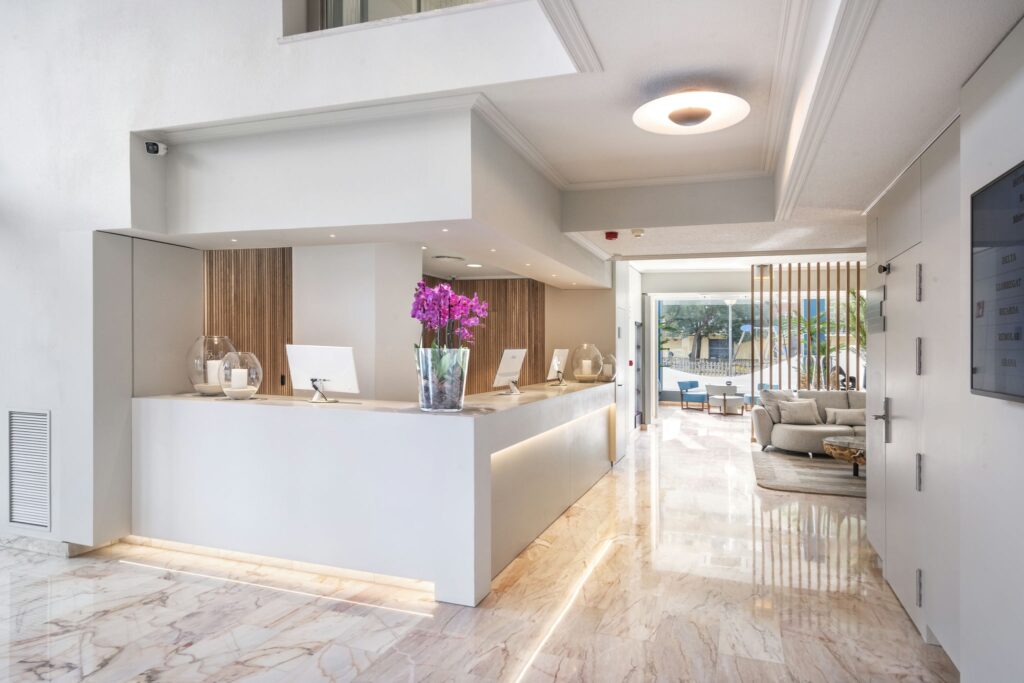 Recepción elegante y moderna Recepción minimalista con mármol y detalles en flores moradas.
