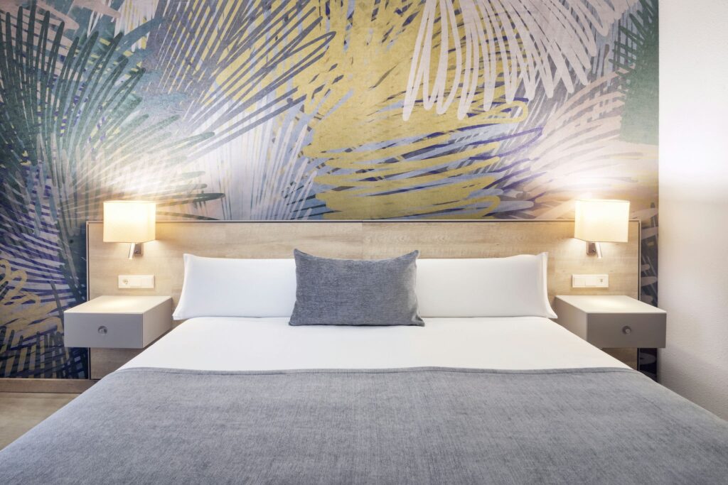 Hotel Ciutat del Prat: Dormitorio moderno con cama doble y pared decorativa única