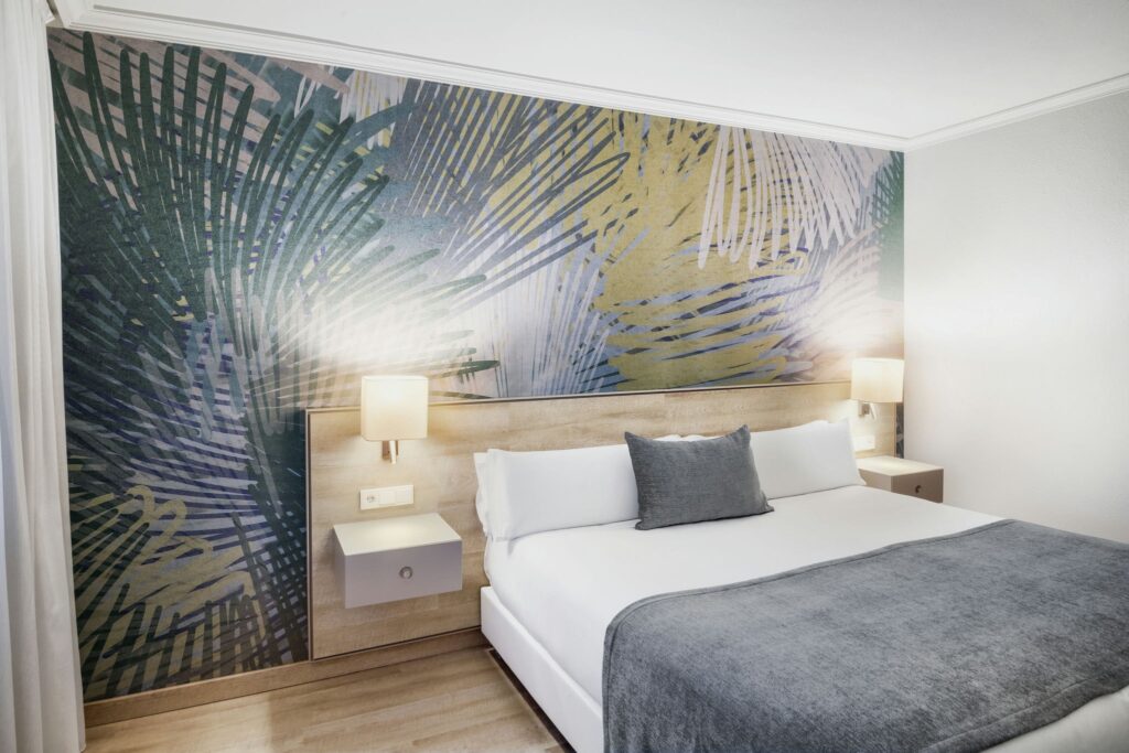 Habitación moderna y tropical Habitación moderna con paredes tropicales y cama de madera clara