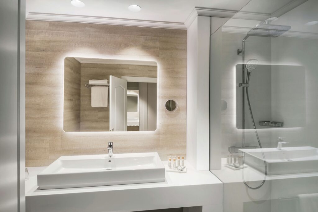 Baño Minimalista Elegante Baño moderno con espejo LED y madera natural.