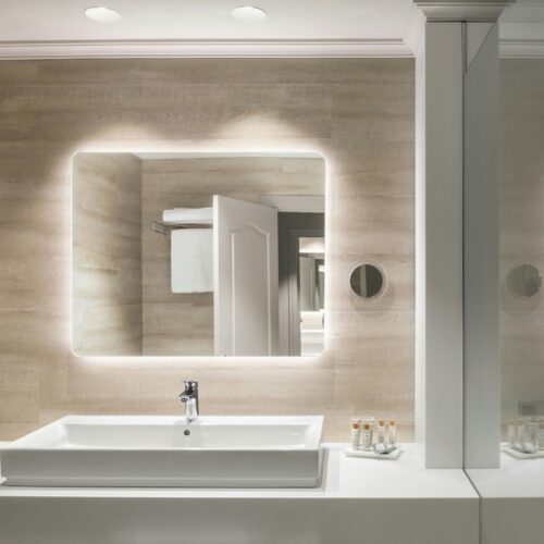 Baño moderno con lavabo blanco y decoración luminosa.