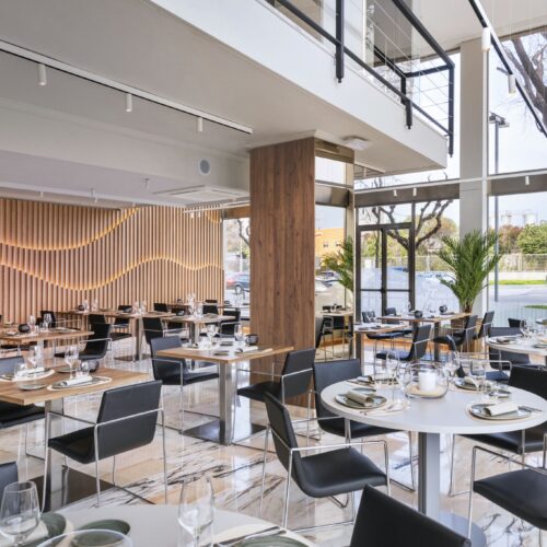 Comedor contemporáneo con muebles de madera y cristal.