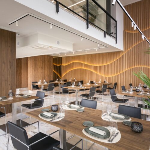 Interior de restaurante moderno con detalles en madera y luz suave.