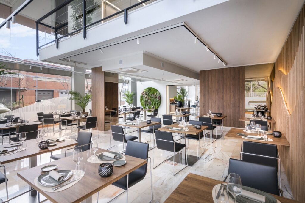 Restaurante elegante y moderno Interior de un restaurante contemporáneo con mesas de madera y sillas negras.