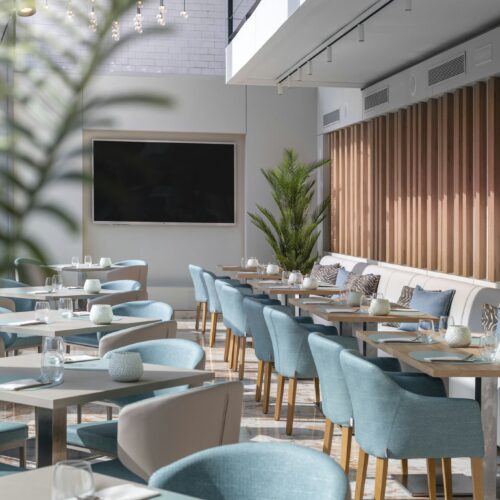 Comedor moderno con asientos azules y decoración en madera cálida.