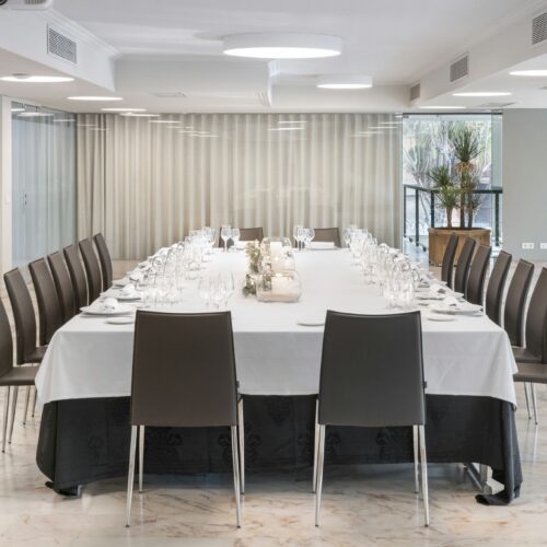 Salón minimalista con mesa larga y sillas de diseño contemporáneo.