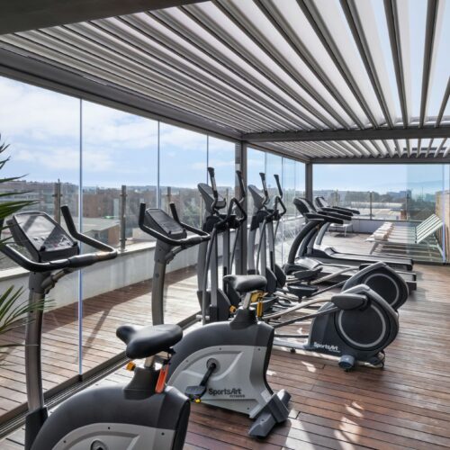 Gimnasio elegante con equipamiento de última generación y luz natural