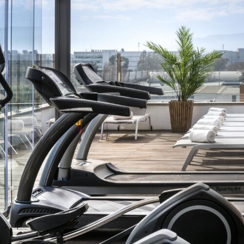Gimnasio con elípticas y área de relax exterior