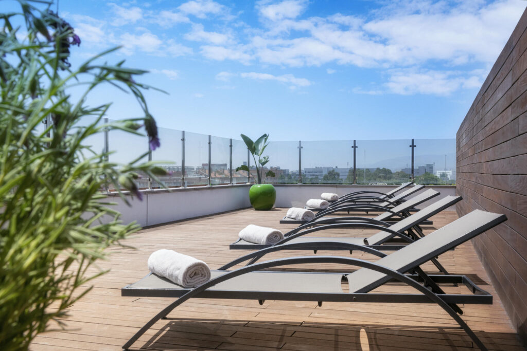 Terraza moderna y acogedora Terraza contemporánea con tumbonas de metal y plantas decorativas.