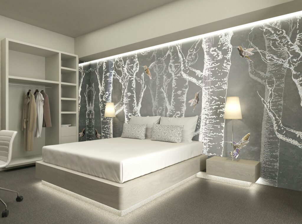 Diseño de dormitorio moderno y minimalista en Barcelona con elementos de lujo Dormitorio moderno con cama de color claro, cabecero simple y pared decorativa con silueta de árbol en gris suave. Incluye lámpara de mesita y silla de oficina contemporánea.