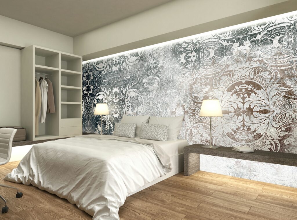 Diseño de interiores moderno en una habitación contemporánea en Barcelona Habitación moderna con cama grande, edredón blanco, almohadas decorativas y pared de patrón en escala de grises, con banco de madera y lámpara de pie.