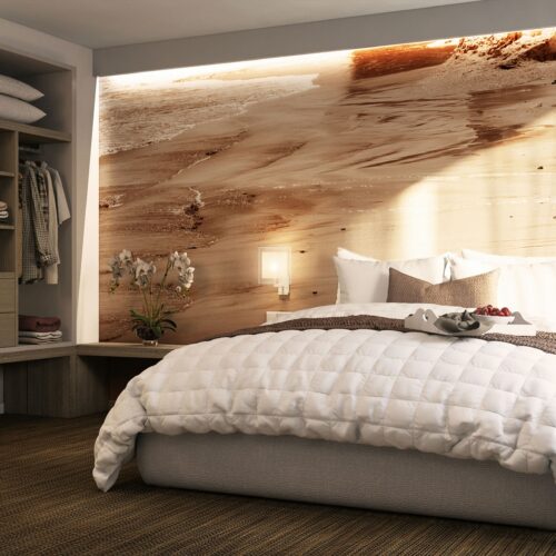 Interior de un dormitorio contemporáneo en Barcelona, con una cama grande, colcha blanca y pared con textura natural, iluminado por luz natural.