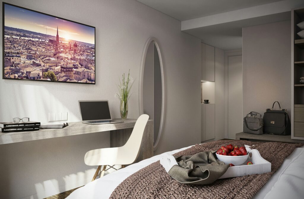 Hôtel Victoire: Dormitorio moderno y sofisticado en Barcelona con cama acogedora, decoración de fresas, escritorio minimalista y pintura vibrante del paisaje barcelonés en la pared.
