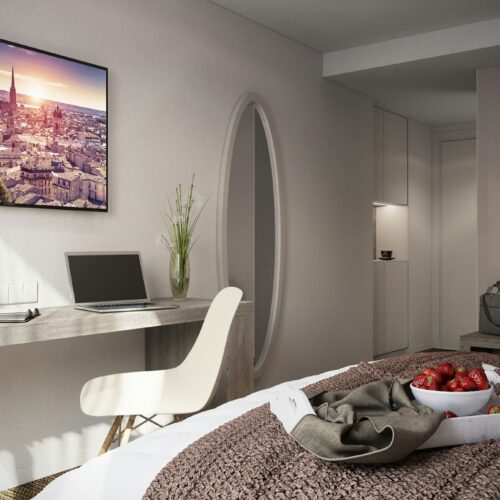 Hôtel Victoire: Dormitorio moderno y sofisticado en Barcelona con cama acogedora, decoración de fresas, escritorio minimalista y pintura vibrante del paisaje barcelonés en la pared.