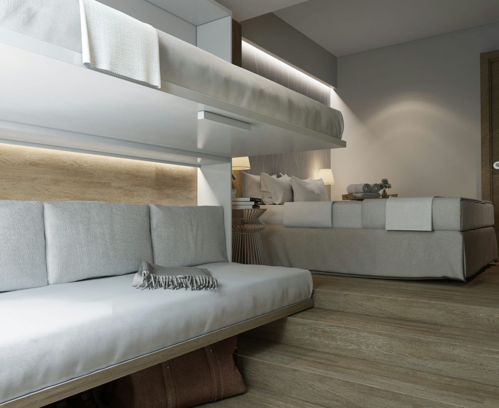 Diseño de interiores de dormitorio moderno en Barcelona con arquitectura de alta gama Interior de un moderno dormitorio en Barcelona con un elegante litera blanca y una acogedora zona de descanso con cojines, destacando materiales de alta calidad y detalles arquitectónicos sofisticados.