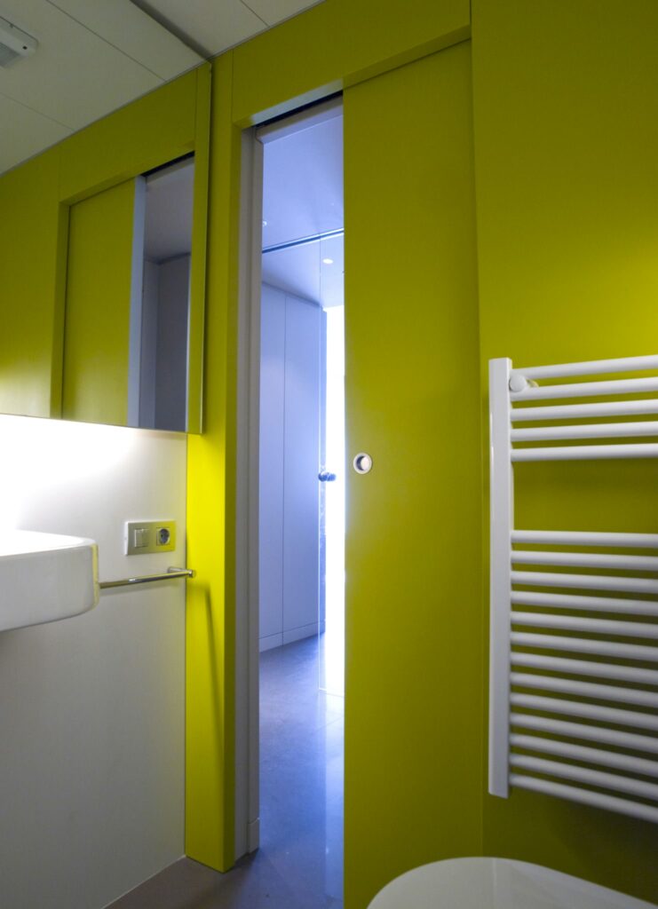 Diseño de interiores de un baño moderno en Barcelona con paredes amarillas vibrantes Interior de un baño contemporáneo en Barcelona con paredes amarillas, equipado con mármol y accesorios personalizados, ofreciendo iluminación natural y un diseño minimalista.