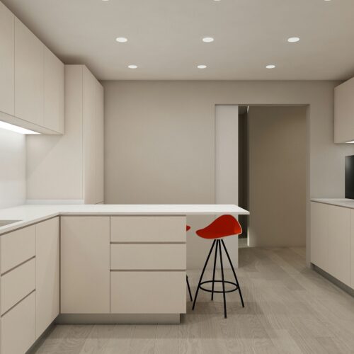 Cocina moderna en Barcelona con arquitectura de alta gama, armarios beige elegantes, un taburete rojo y abundante luz natural que destaca su funcionalidad y estética contemporánea.
