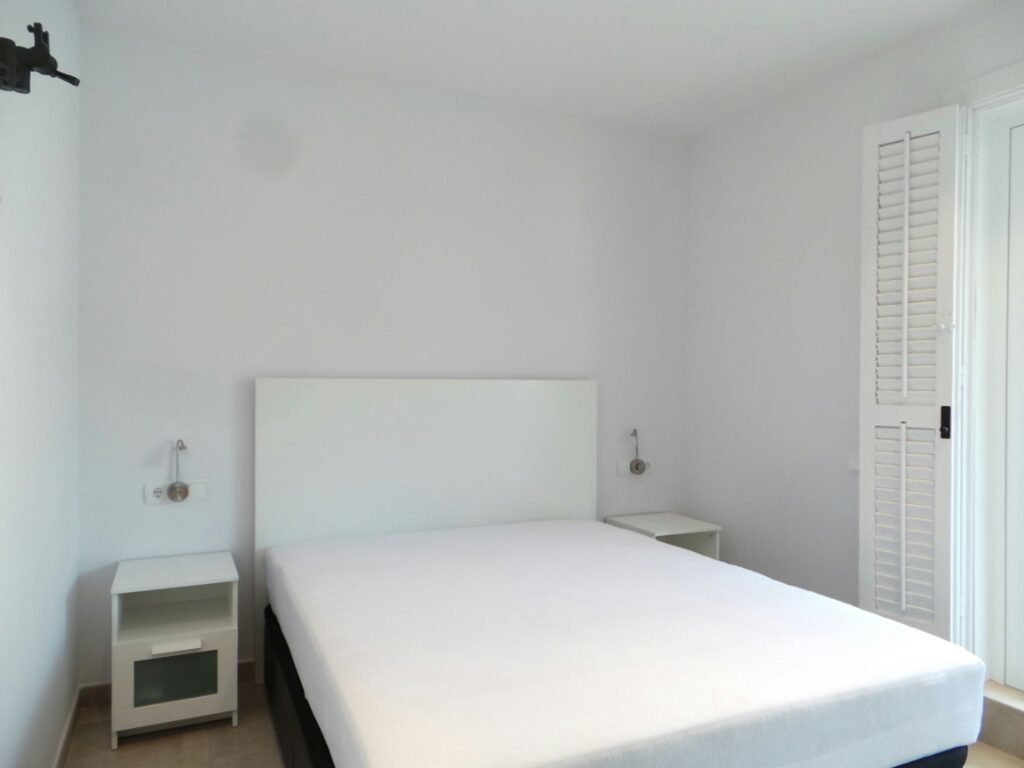 Diseño de interiores en un dormitorio moderno en Barcelona Dormitorio luminoso y moderno en Barcelona con diseño de alta gama, presentando un marco de cama minimalista, mesitas de noche elegantes y luz natural.