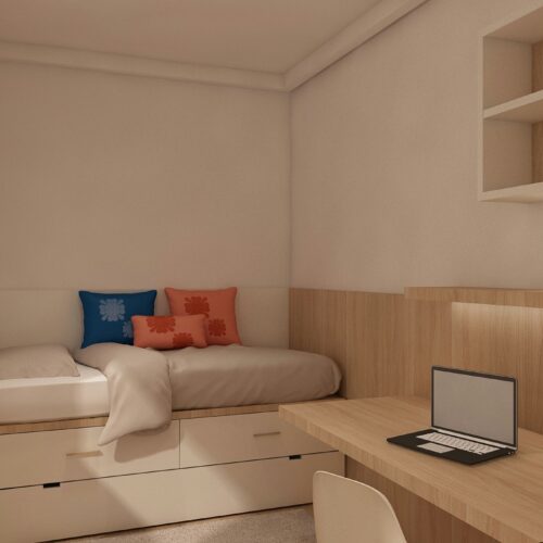 Proyecto de diseño de interiores moderno en Barcelona, mostrando una acogedora habitación con una cama estilizada, cojines decorativos coloridos, un escritorio elegante con laptop, y detalles en madera que resaltan la luz natural.