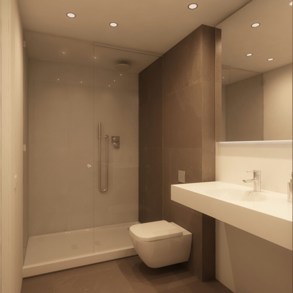 Diseño de baño moderno de alta gama en Barcelona Baño contemporáneo en Barcelona con ducha de cristal, lavamanos montado en la pared y materiales de mármol. La iluminación suave resalta la combinación de tonos neutros y cálidos, reflejando una estética de lujo y funcionalidad.