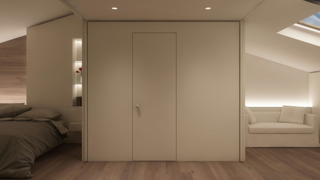 Diseño de interiores moderno en un apartamento de lujo en Barcelona Habitación minimalista de alto nivel en un apartamento moderno de Barcelona, con paleta de colores suaves y una disposición funcional. Incluye un área de descanso junto a la ventana, un armario integrado y suelos de madera cálida, destacando la estética contemporánea.