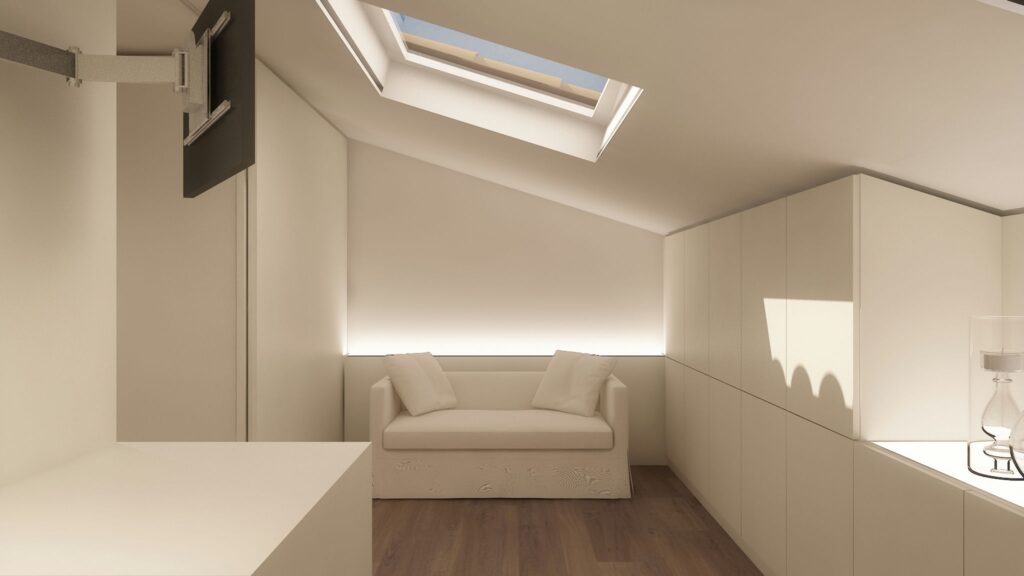Diseño de interiores moderno en ático de Barcelona con luz natural Diseño de interiores de un espacio moderno en un ático de Barcelona, con paredes blancas y un sofá minimalista, resaltando la iluminación natural proveniente de una ventana de techo y mobiliario funcional en madera.