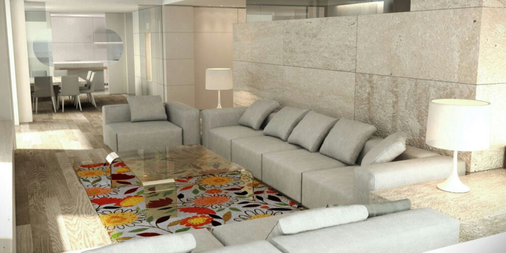 Salón contemporáneo en Barcelona con sofá gris claro, mesa de cristal y alfombra floral, destacando iluminación natural y detalles arquitectónicos de alta calidad.