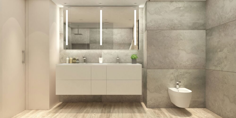 Baño moderno y lujoso en Barcelona con diseño arquitectónico de alta gama, featuring cabinetry blanca, paredes de piedra gris y piso de madera cálida, iluminado naturalmente con instalaciones minimalistas.