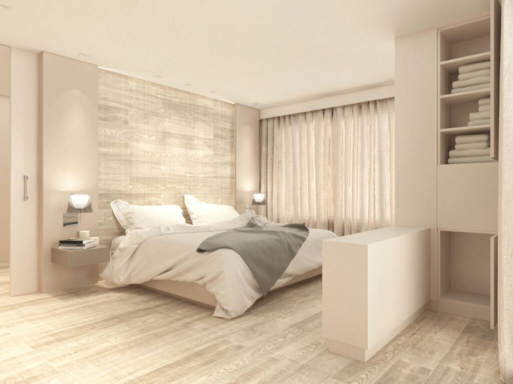 Diseño de interiores moderno de un dormitorio de alta gama en Barcelona Interior de un dormitorio contemporáneo en Barcelona con paleta de colores claros, suelo de madera y pared texturada. Destacan una cama grande con ropa de cama acogedora, lámparas de mesita elegantes y abundante luz natural a través de cortinas translúcidas. Mobiliario minimalista y detalles arquitectónicos sutiles que reflejan funcionalidad y estética.